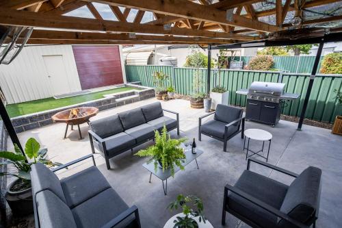 an outdoor patio with couches and a grill at Cabo’s On Currajong Warm, Cosy and Welcoming in Parkes