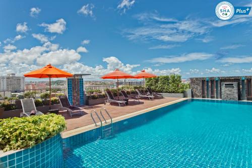 a swimming pool on the roof of a building with umbrellas at Adelphi Pattaya in Pattaya