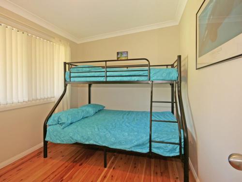 two bunk beds with blue sheets in a room at Bring the Dog, Boat and Family in Burrill Lake