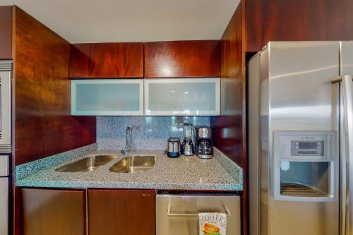 una cocina con fregadero y frigorífico en Hakuna Matata 725N at Mareazul Beachfront, en Playa del Carmen