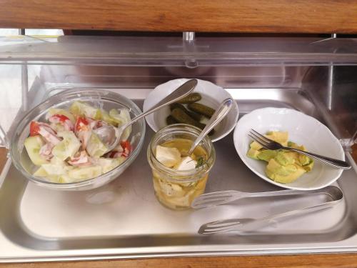 a plastic tray with two bowls of food and a salad at Hotel Belcredi in Brno