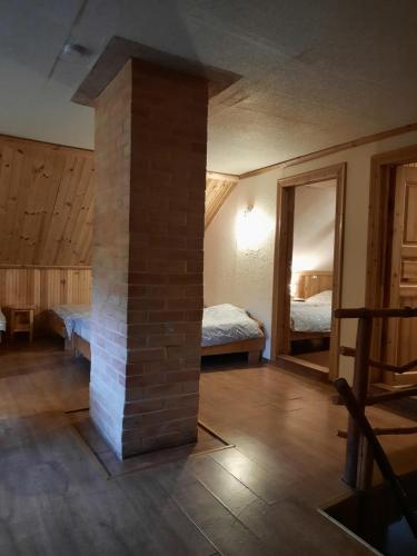 ein Zimmer mit einem gemauerten Kamin und einem Schlafzimmer in der Unterkunft Holiday Home Atmatas in Sabile