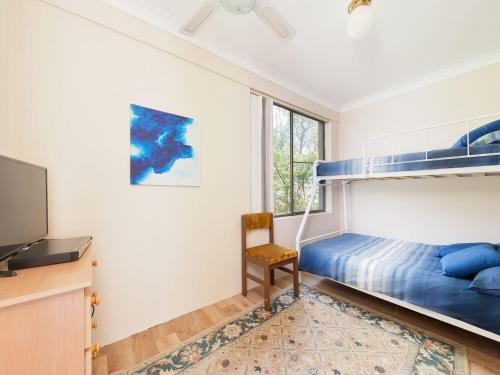 a bedroom with a bunk bed and a tv at The Poplars Unit 31 34 Magnus Street in Nelson Bay