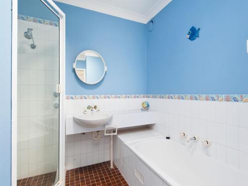 ネルソン・ベイにあるThe Poplars Unit 31 34 Magnus Streetの青いバスルーム(シンク、鏡付)