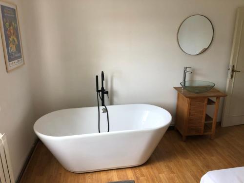 bañera blanca en una habitación con espejo en Villa La Mer - maison typique et jardin à Berck-Plage à 300 m de la mer en Berck-sur-Mer