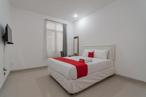 ein Schlafzimmer mit einem großen Bett mit roten und weißen Kissen in der Unterkunft Hotel Sukahaji Street Bandung Redpartner in Bandung