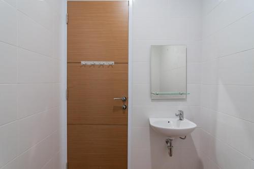 een badkamer met een wastafel en een spiegel bij Hotel Sukahaji Street Bandung Redpartner in Bandung
