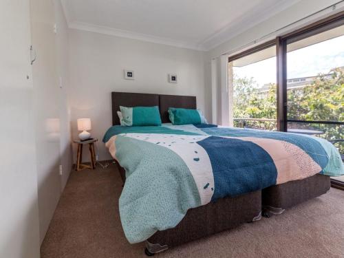 a bedroom with a large bed and a window at Tradewinds Unit 3 110 Victoria Parade in Nelson Bay
