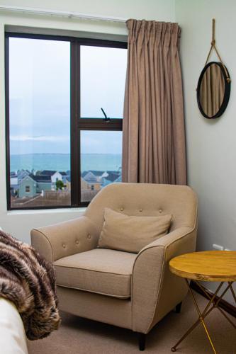 a living room with a chair and a window at Waves Edge CP3 in Cape Town