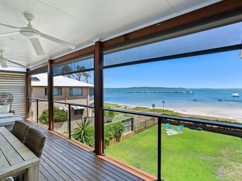 a balcony with a view of the beach and ocean at Waterfront at Sunset Boulevard 26 Sunset Boulevard in Soldiers Point