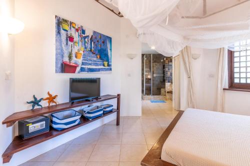 A television and/or entertainment centre at Tequila Sunrise Forest Cabana - on Diani Beach