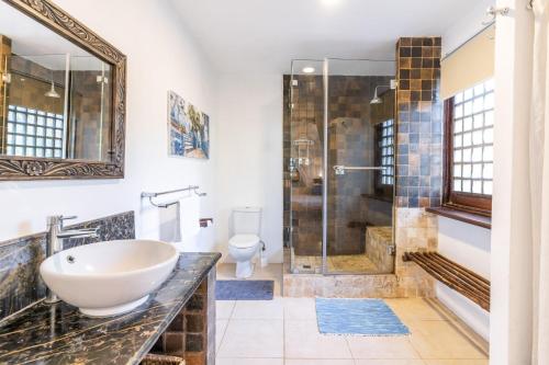 a bathroom with a sink and a shower at Tequila Sunrise Forest Cabana - on Diani Beach in Diani Beach