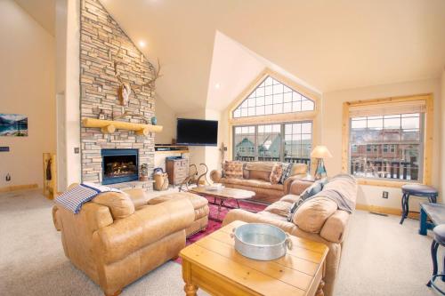 a living room with couches and a fireplace at 67 Fireweed 27A by Stay Winter Park in Tabernash