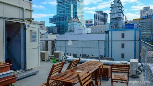 a table and chairs on a balcony with a city skyline at City view guesthouse Private room - Vacation STAY 85052 in Osaka