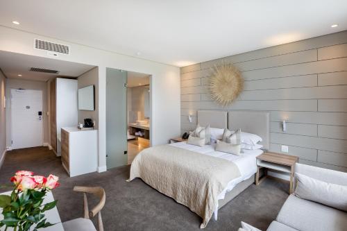 Bluewater Bay Sunrise Hotel في Amsterdamhoek: غرفة نوم مع سرير وغرفة معيشة