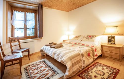 une chambre avec un lit, une chaise et une fenêtre dans l'établissement le chalet d'auguste 2 à 12 personnes, à Morzine
