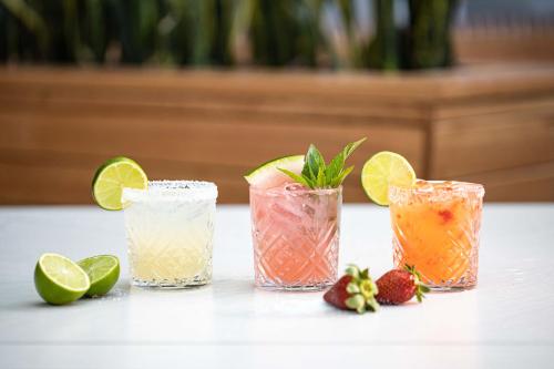 three cocktails with lime and strawberries on a table at The Peakhurst in Peakhurst