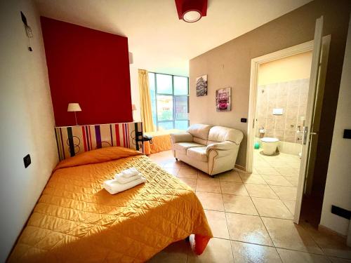 a bedroom with a bed and a couch and a chair at Hotel Le Ceramiche in Montalto Uffugo
