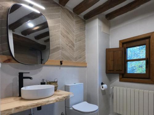 W łazience znajduje się umywalka, toaleta i lustro. w obiekcie Molino del Corregidor w mieście San Román de Cameros