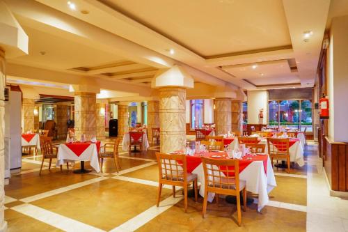 a restaurant with red and white tables and chairs at Charmillion Club Aquapark in Sharm El Sheikh
