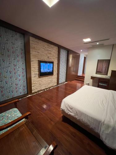Charming Motel في مدينة هوالين: غرفة نوم بسرير وتلفزيون على جدار