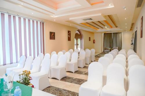 a conference room with white chairs and tables at Charmillion Club Aquapark in Sharm El Sheikh