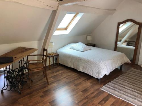 羅莫朗坦的住宿－Le Grand Appartement - 90m2- 2 chb , 1 mezzanine - 6pers，一间卧室配有一张床、一张桌子和一面镜子