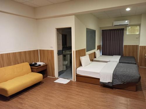 a bedroom with a bed and a couch in a room at 九族飯店 臺東縣旅館004號 in Wenquan
