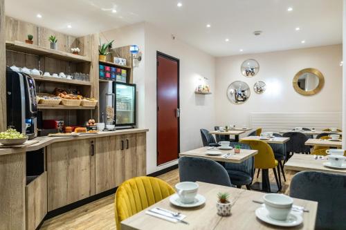 a restaurant with tables and chairs and a counter at Hôtel Le Florin in Rennes