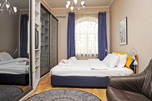 キーウにあるPremium Rent in Kiev Centre - Kievのベッド2台とソファが備わるホテルルームです。