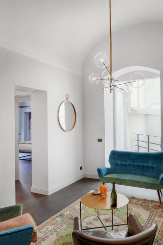 a living room with a blue couch and a table at Relais Antica Badia - San Maurizio 1619 in Ragusa
