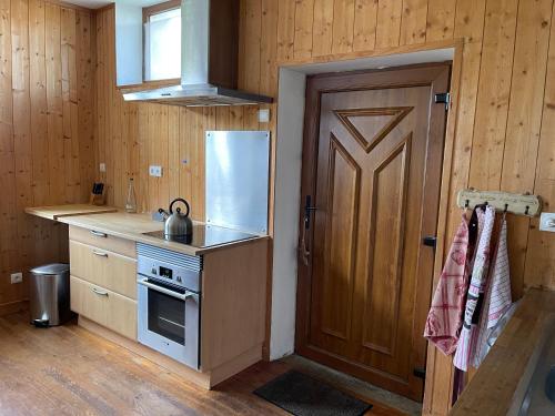 a kitchen with a door and a stove and a refrigerator at Appart' Côté Puy-de-Dôme in Orcines