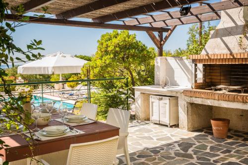a patio with a table and an outdoor kitchen at Villa Petri in Trapezaki