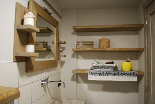 a bathroom with a sink and shelves and a toilet at La casa indaco in Frabosa Sottana