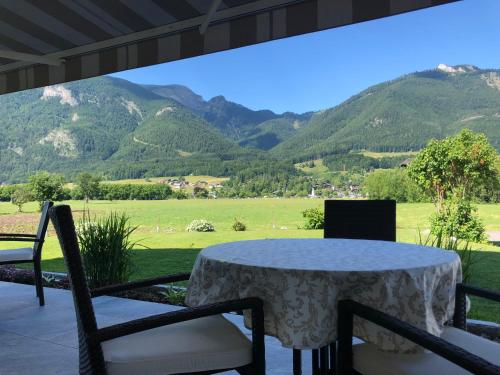 a table and chairs with a view of mountains at Gästehaus Kloibergütl in Sankt Gilgen