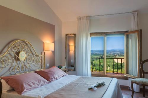 ein Schlafzimmer mit einem Bett und einem großen Fenster in der Unterkunft Hotel San Michele in San Gimignano