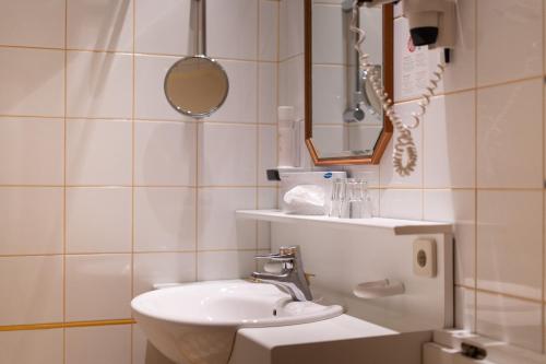 a white bathroom with a sink and a mirror at Gasthof Post in Rennweg