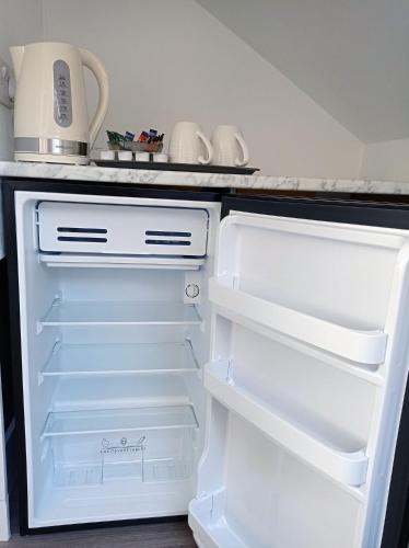an empty refrigerator with its door open in a kitchen at Mill Studio A - Self contained one bed studio flat in Oxford