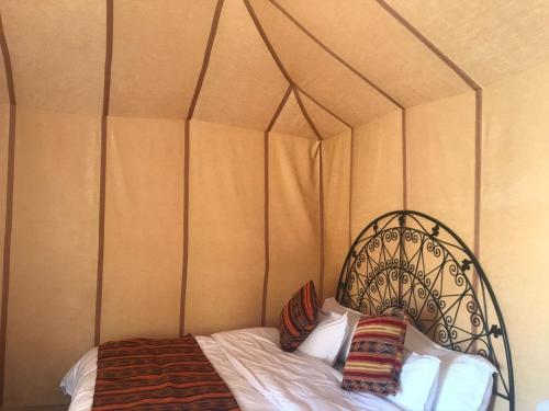 a bed in a tent with two pillows on it at Merzouga Luxury Tents - Glamping in Merzouga
