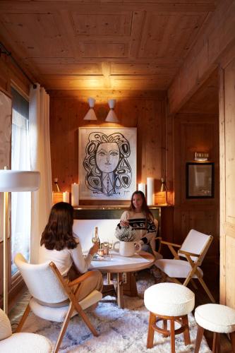 two women sitting at a table in a room at Hotel Mont Blanc Megève in Megève