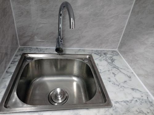 a stainless steel sink with a faucet on a counter at Mill Studio A - Self contained one bed studio flat in Oxford