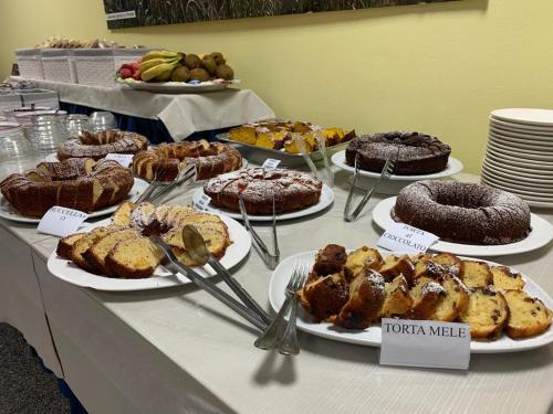 a table with different types of cakes and pastries at Hotel Rondine in Marinella di Sarzana