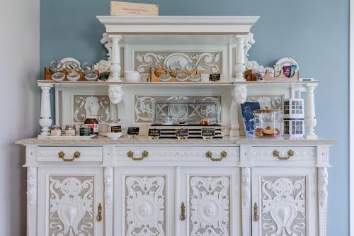 a white hutch with a lot of items on it at L'aja della Mirusina - Piedmont Resort Monferrato Langhe in Canelli