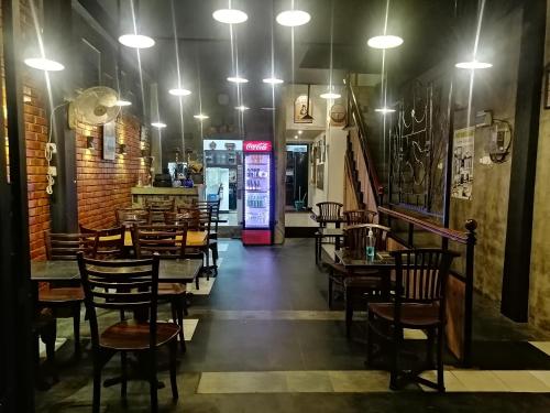 a dining room with tables and chairs and lights at Le Petit Hotel & Restaurant in Negombo