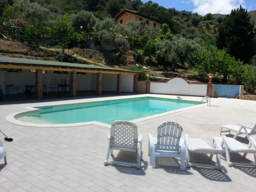 a swimming pool with two chairs and a swimming pool at L'Uliveto in Reitano