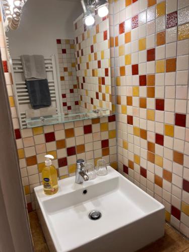 La salle de bains est pourvue d'un lavabo blanc et d'un miroir. dans l'établissement Appart' Côté Puy-de-Dôme, à Orcines