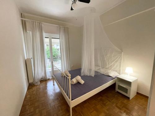 a white crib in a room with a window at Faliro Apartments Next To The Beach in Athens