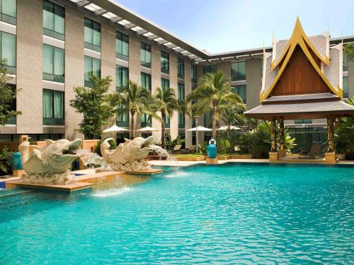 a large swimming pool in a tropical setting at Novotel Bangkok Suvarnabhumi Airport - SHA Extra Plus Certified in Lat Krabang