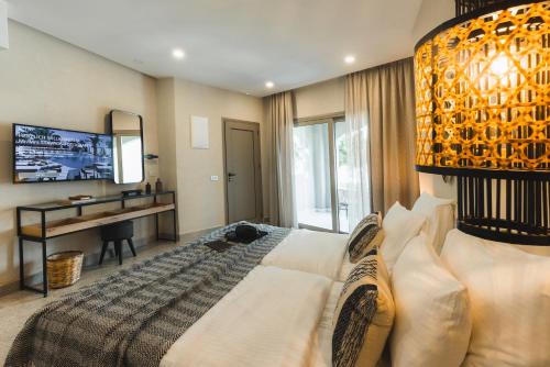 a bedroom with a bed and a desk and a mirror at Eliros Mare Beachfront Poem Hotel in Georgioupolis