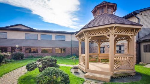 a wooden gazebo in front of a house at Best Western Lapeer Inn in Lapeer